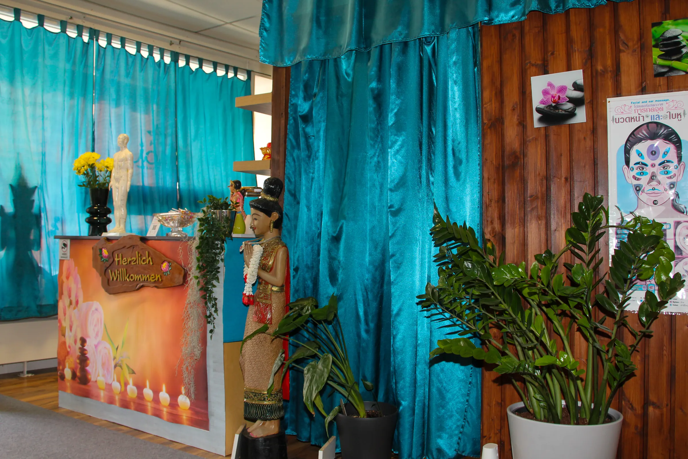 Empfangstheke mit Pflanzen und thailändischer Figur bei BIU Thai Massage Kelheim