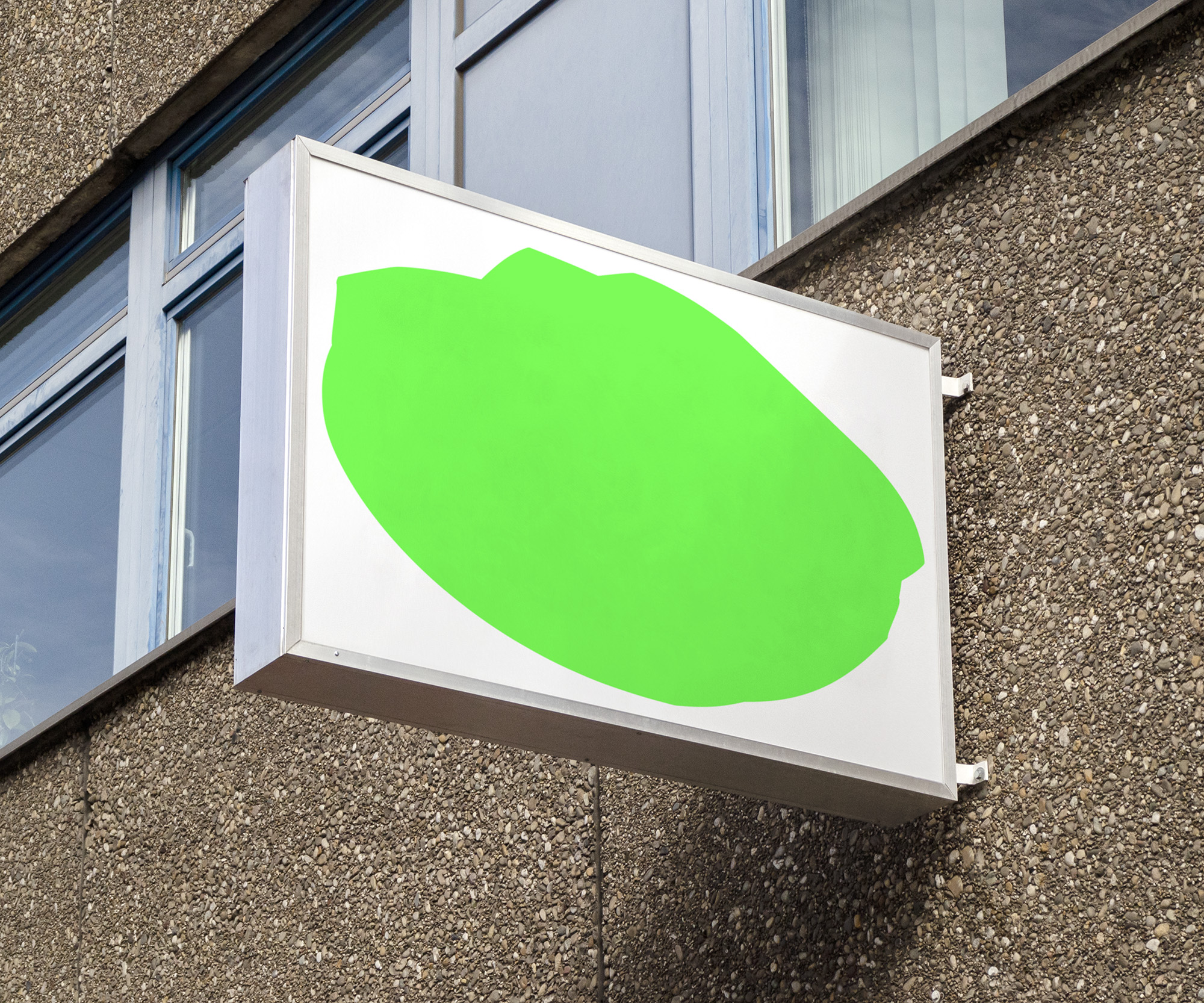 A rounded, asymmetrical, fluorescent green shape on a white backlit store sign.