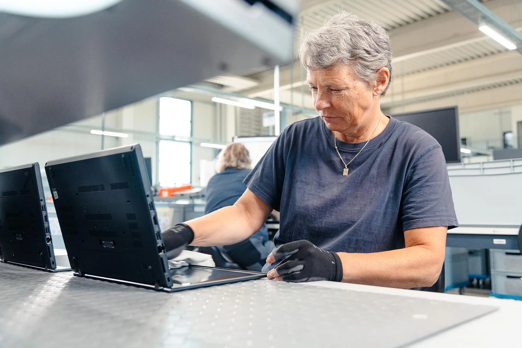 Eine Mitarbeiterin überprüft einen Laptop