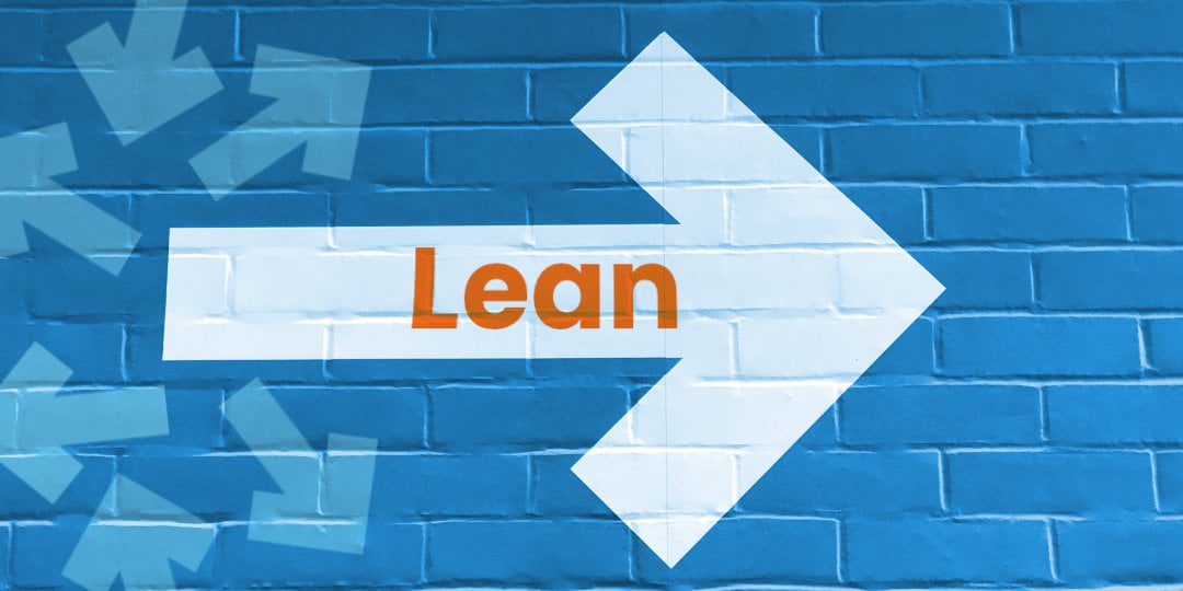 white arrow painted on blue brick wall pointing right with text reading lean to represent the new way forward in us manufacturing 