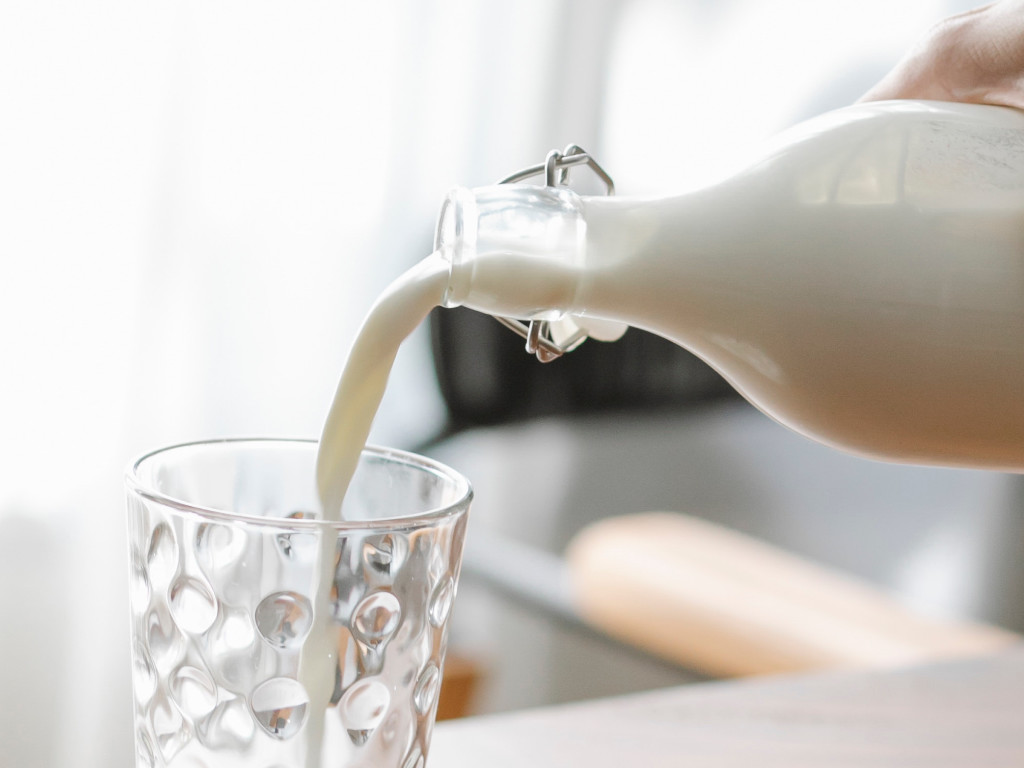 pouring a glass of milk from a glass bottle