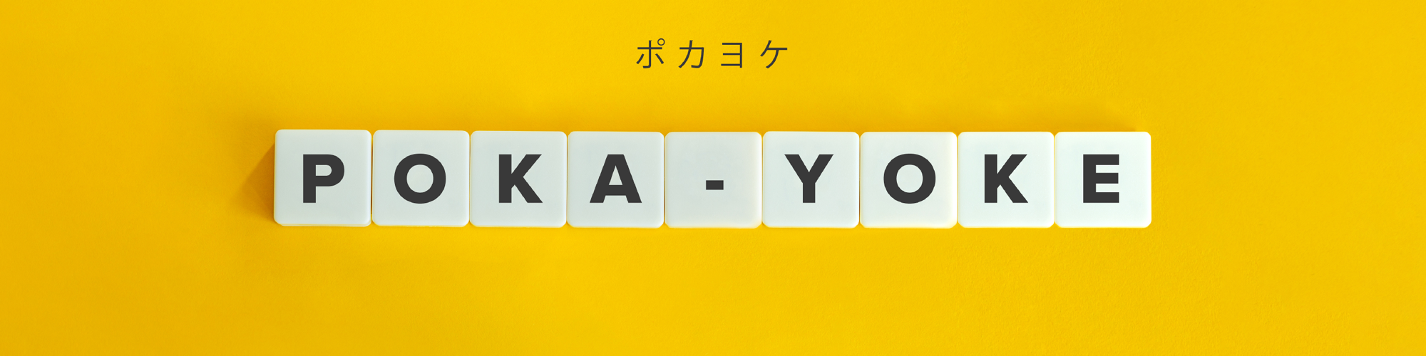 PokaYoke spelled out using white tiles with yellow background