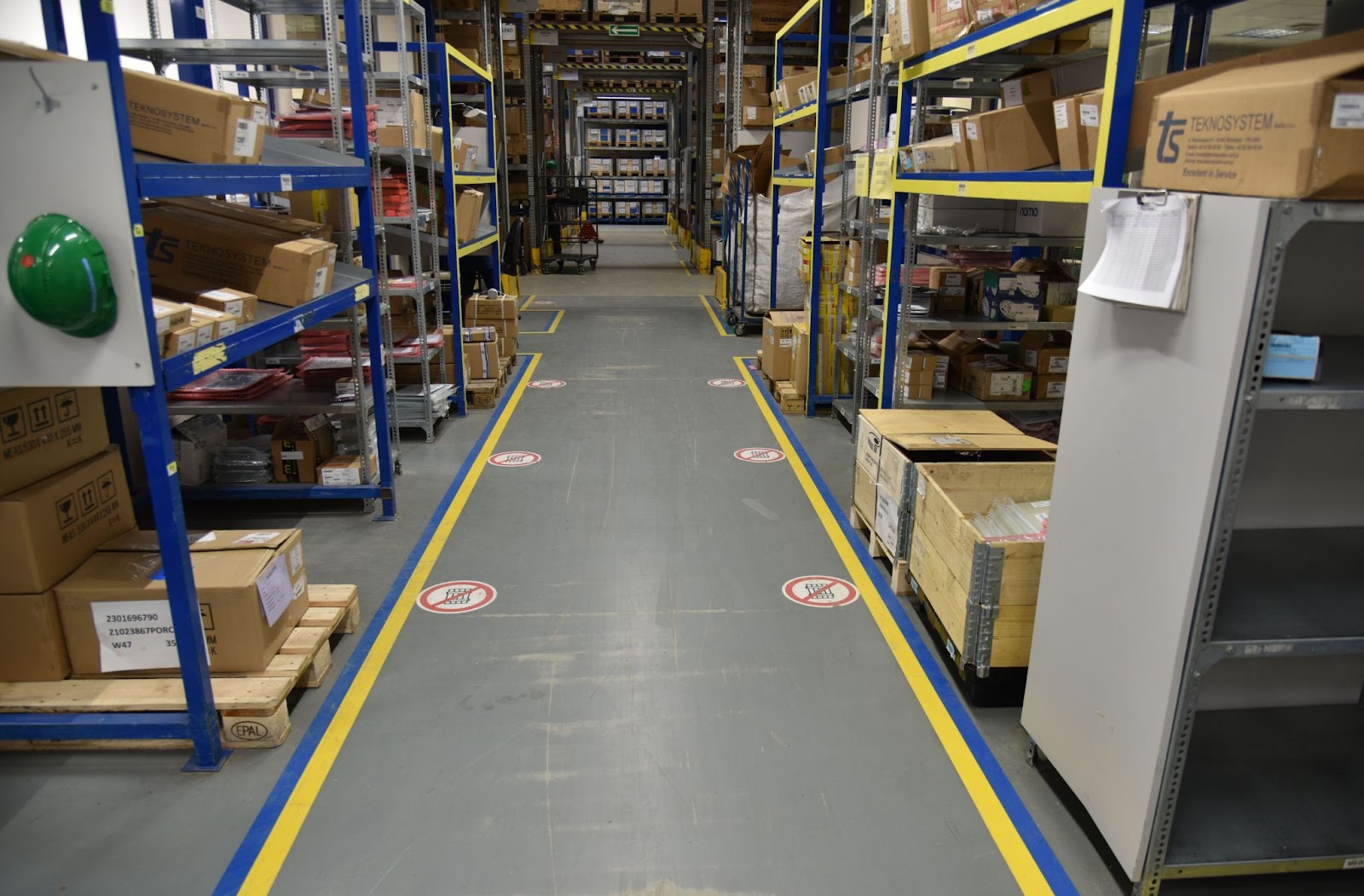 floor markings in warehouse such as  lanes for forklifts, directions for pickers and stockers in the inventory area, and clear labels on machines