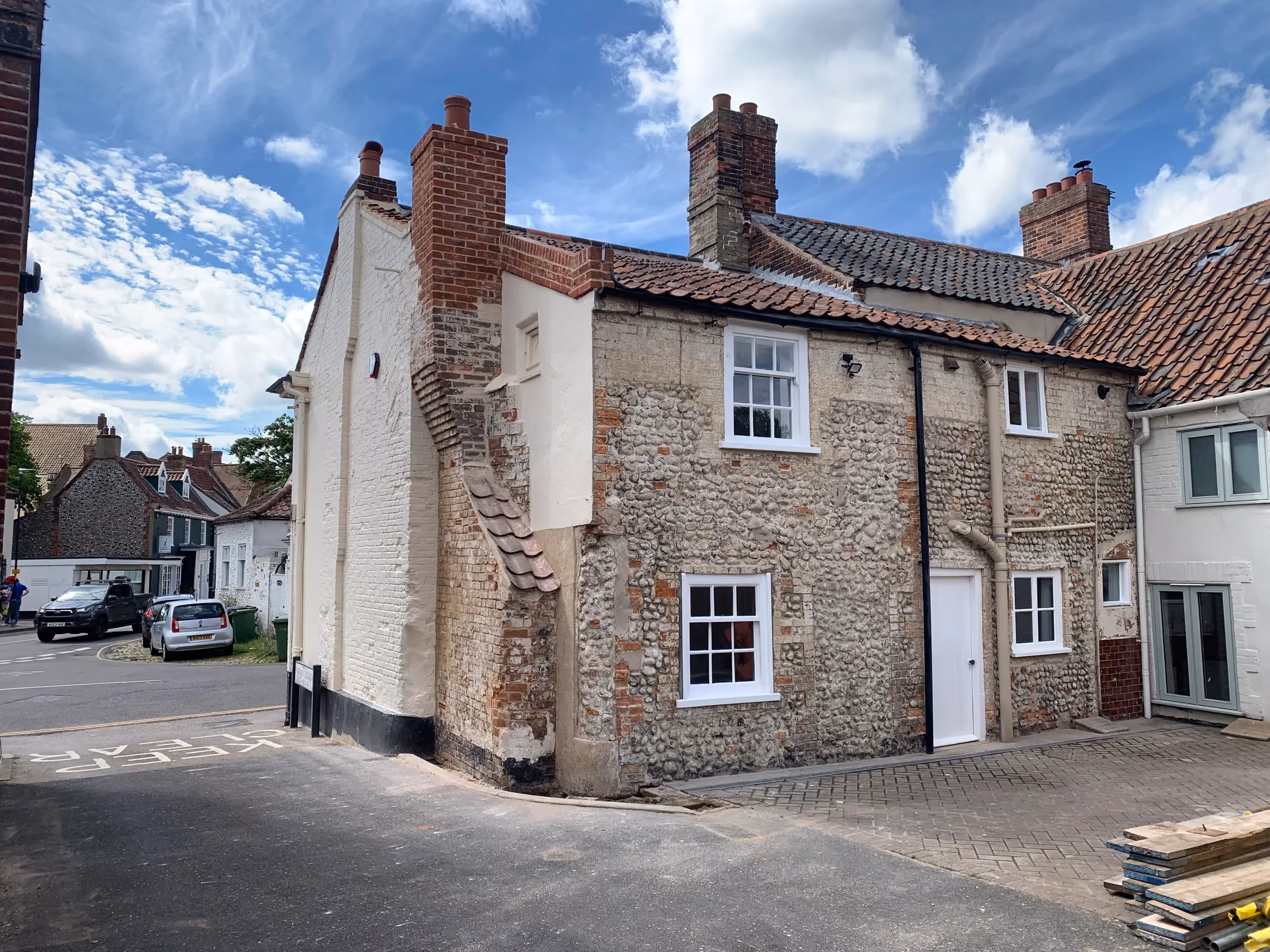 Restored Georgian building in Holt with repointed brick and flint walls, a rebuilt brick chimney and new sash windows
