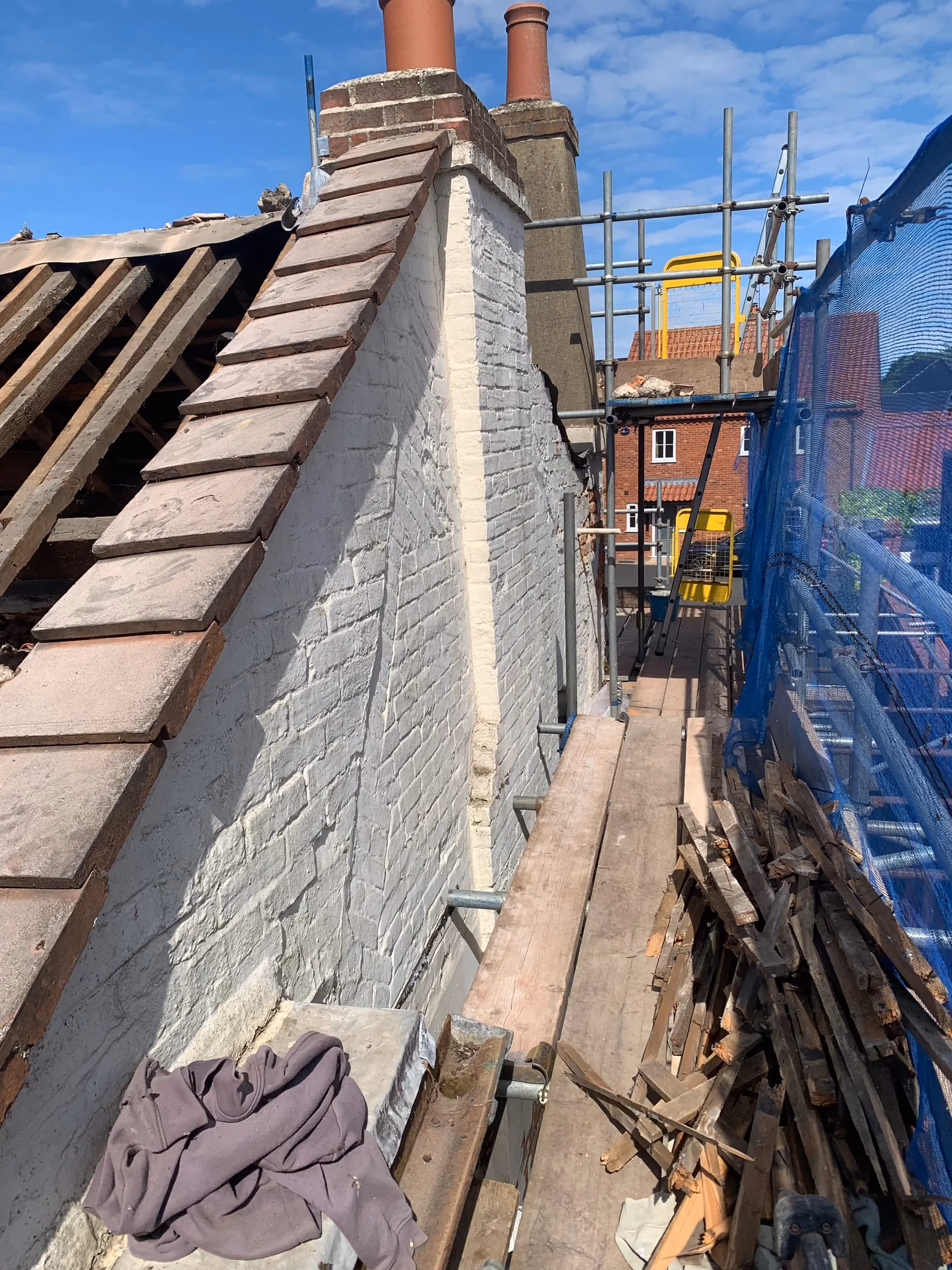 Scaffold walkway alongside the painted gable end during the roof works