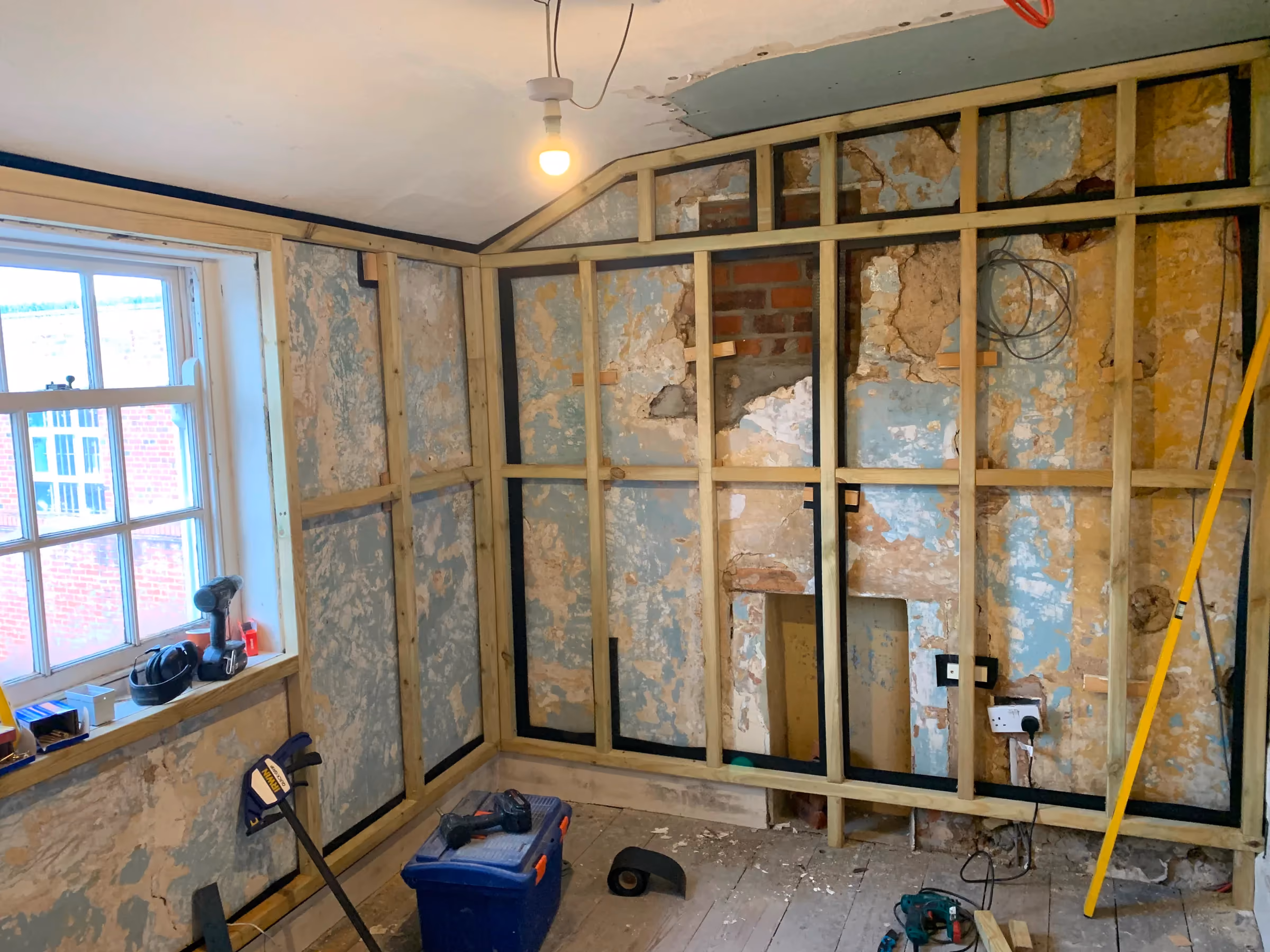 Treated timber stud framing built inside the back room in front of the stripped original wall