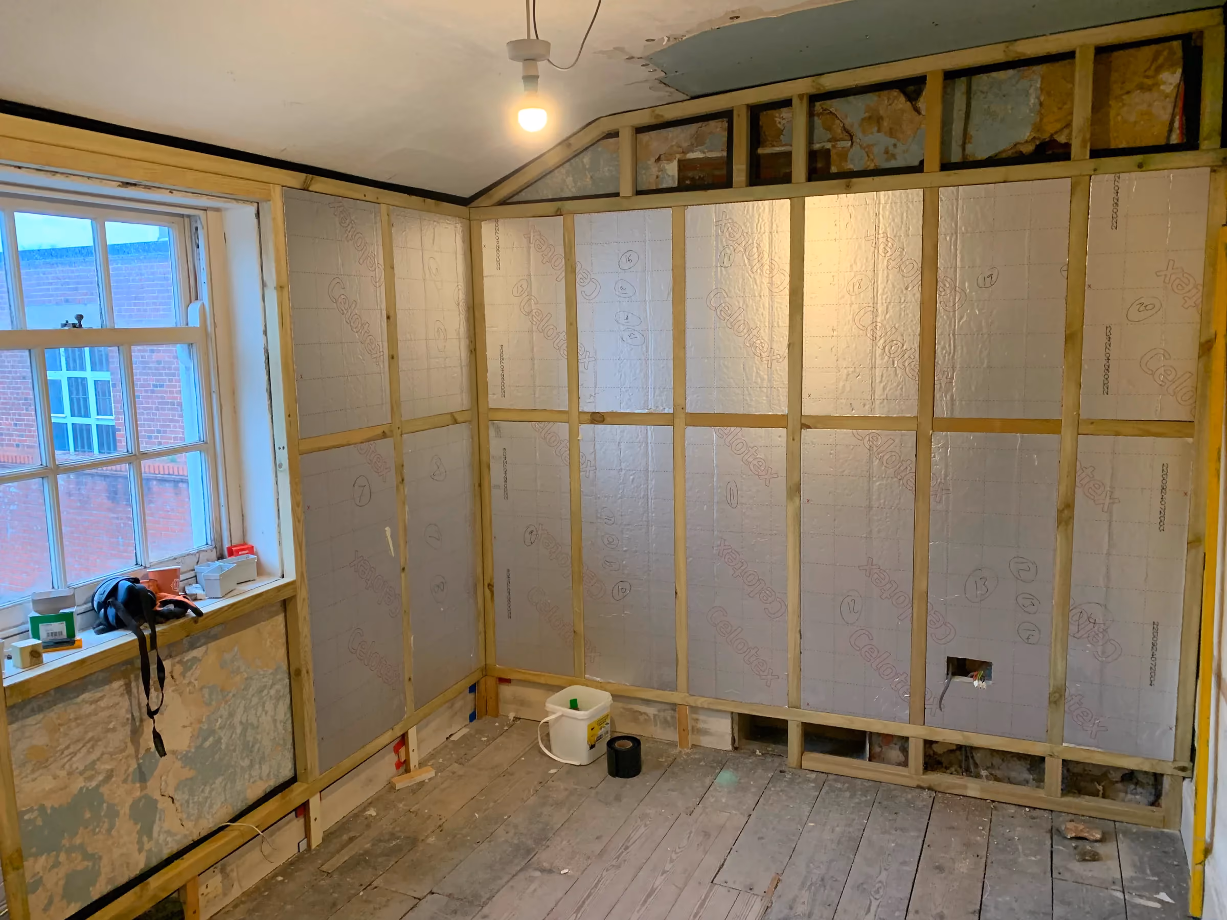 Rigid insulation fitted between the new timber studs in the back room