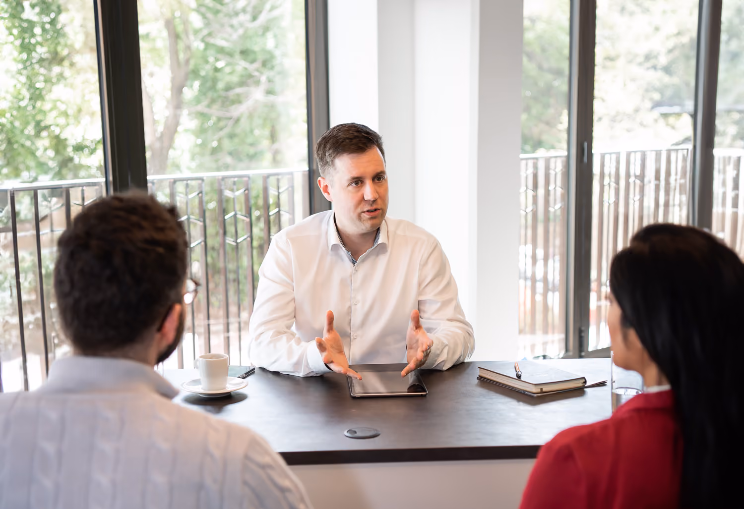 A man sitting at a table talking to a couple.