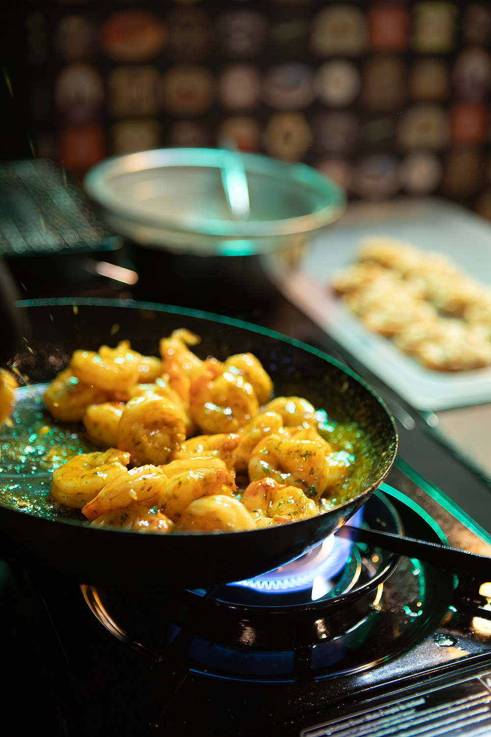 A photo of prawns being sauted in a frying pan over a gas cooktop.