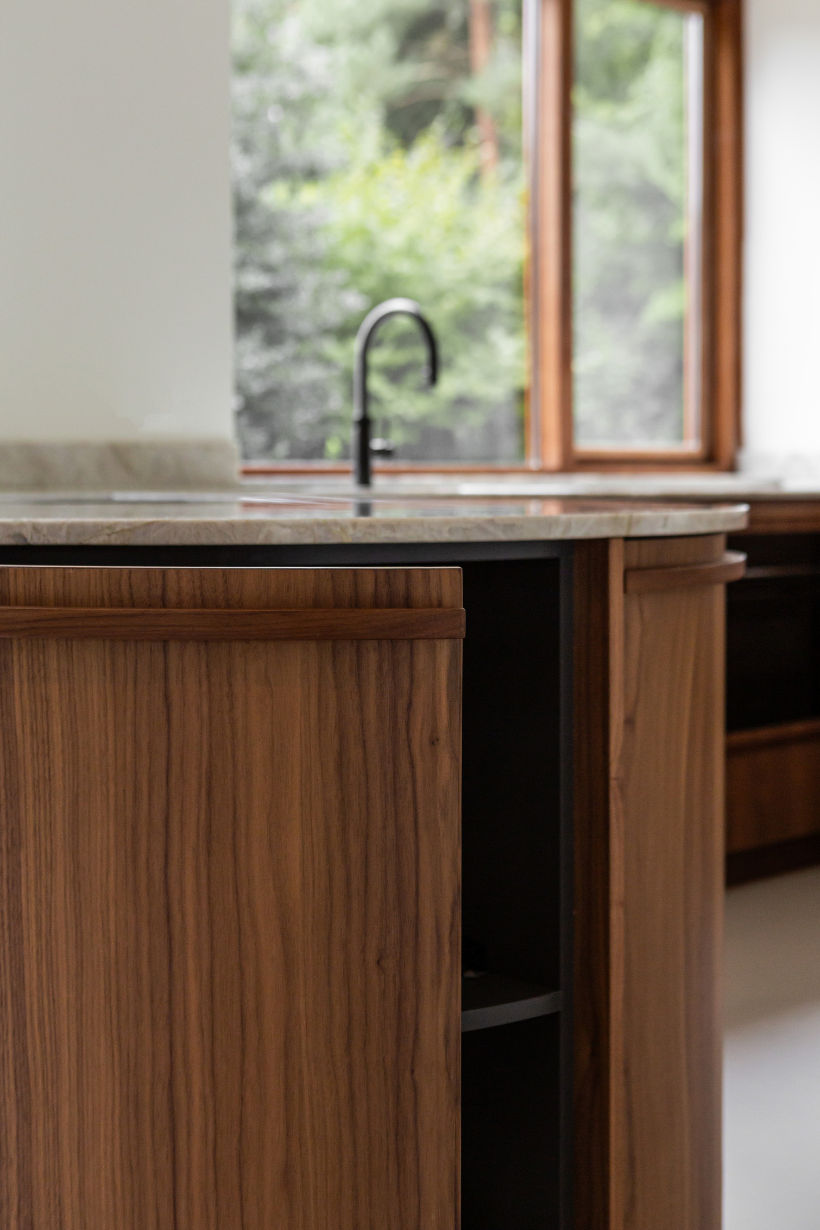 Detail van ronde walnoothouten keukenkastdeuren