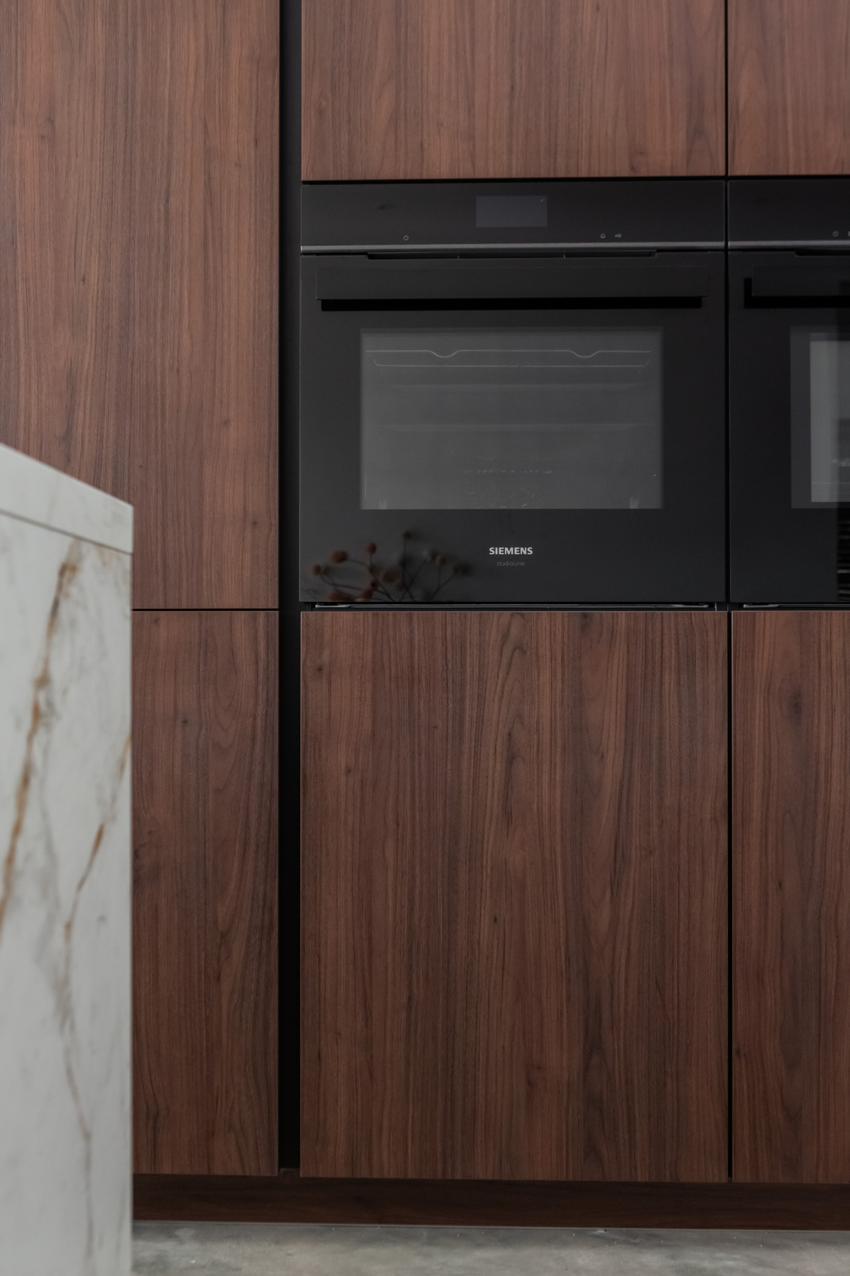 Keuken hoge kasten in notenhout modern en greeploos