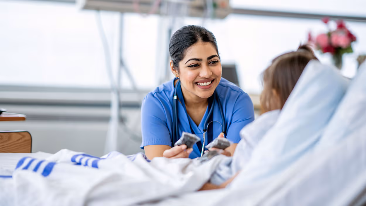 extended stay for travel nurses - woman nurse smiling at patient