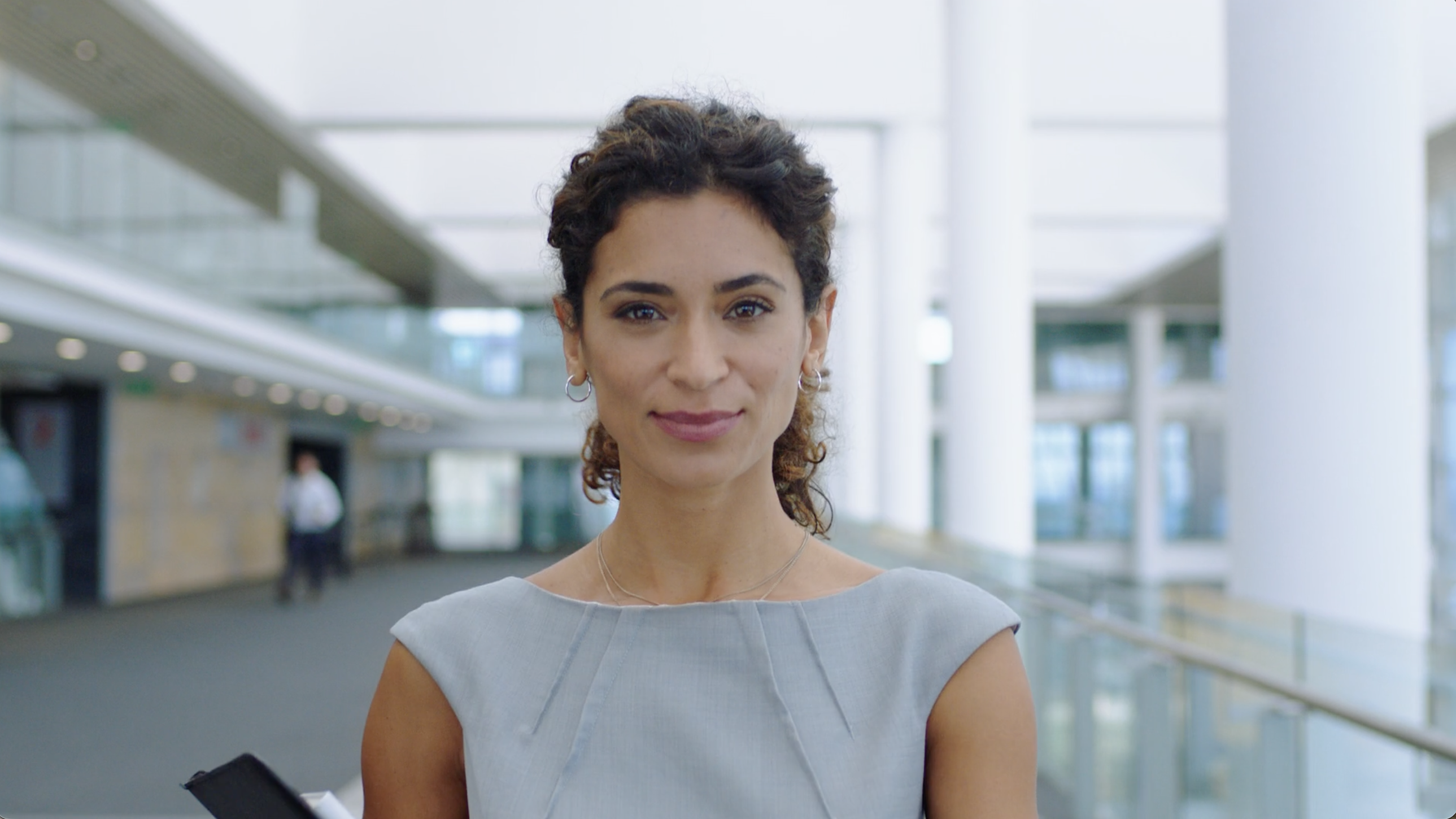 A confident business woman with a wry smile looks at the camera