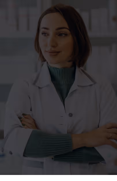 Woman scientist or doctor wearing a white lab coat and green sweater, standing with crossed arms and looking to the side.