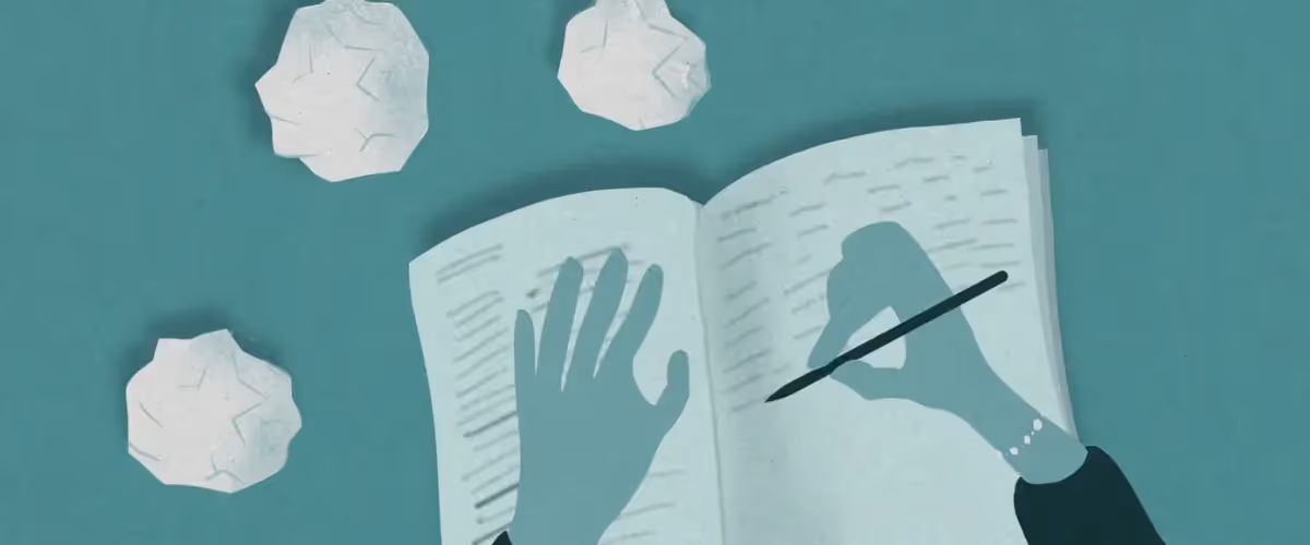 Illustration of hands writing in a notebook with screwed-up balls of paper surrounding it.