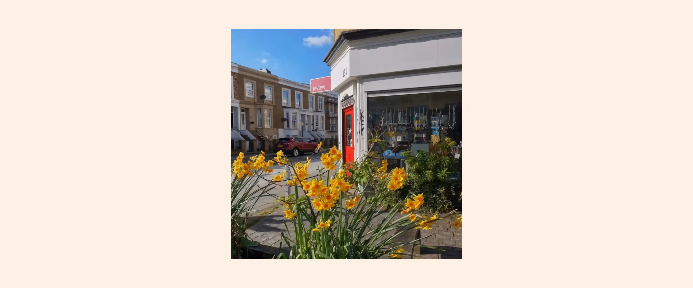 Exterior view of Review Bookshop, London, with daffodils in the foreground.