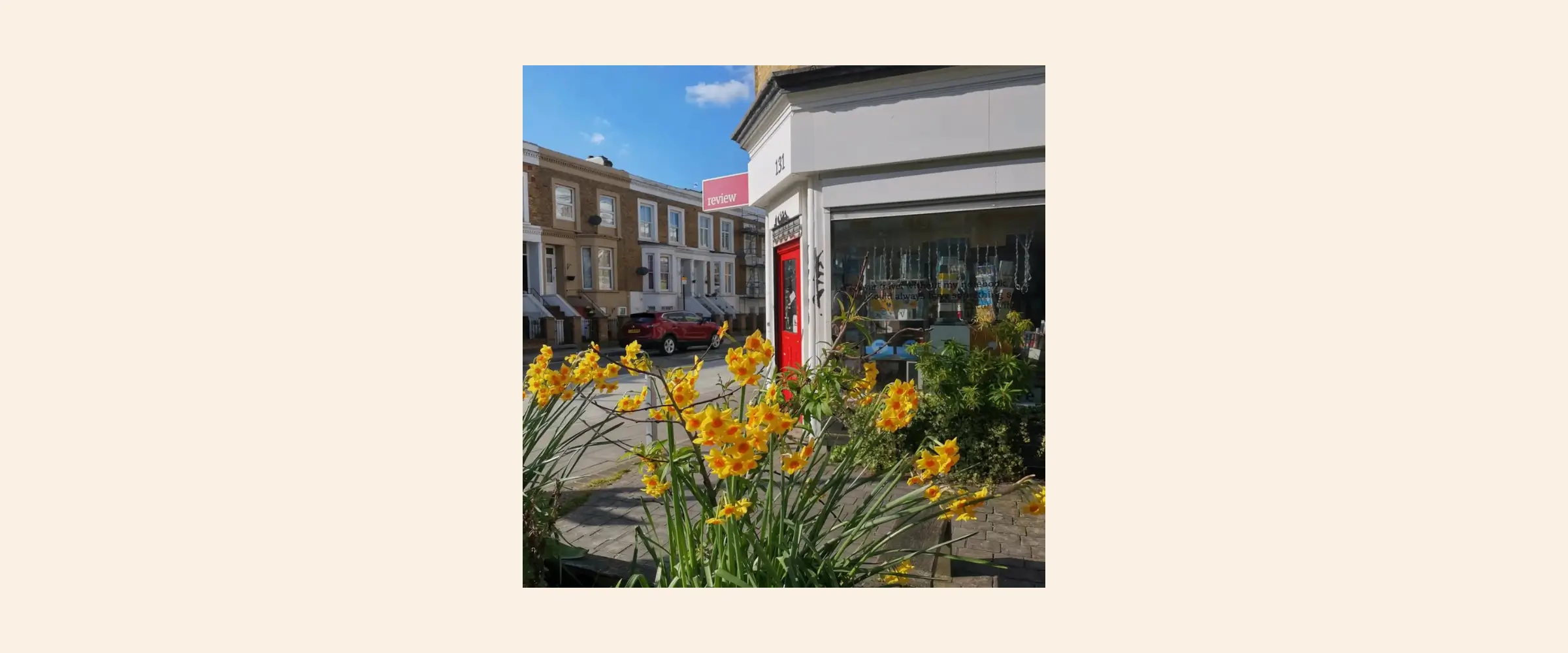 Exterior view of Review Bookshop, London, with daffodils in the foreground.