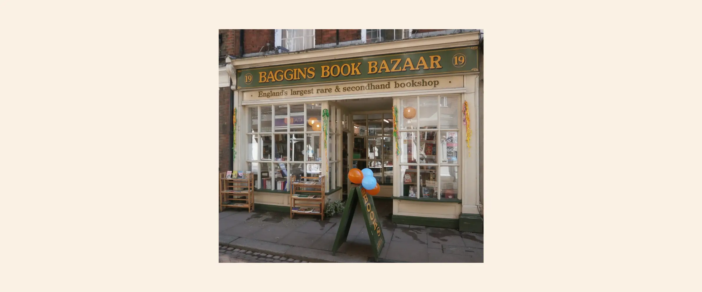 Exterior shot of Baggins Book Bazaar, Kent, colorful balloons tied to a sign outside.
