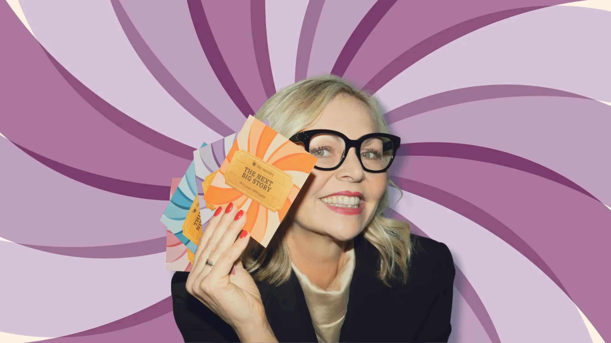 Founder of The Novelry, Louise Dean, holding cards to celebrate The Next Big Story writing competition.l