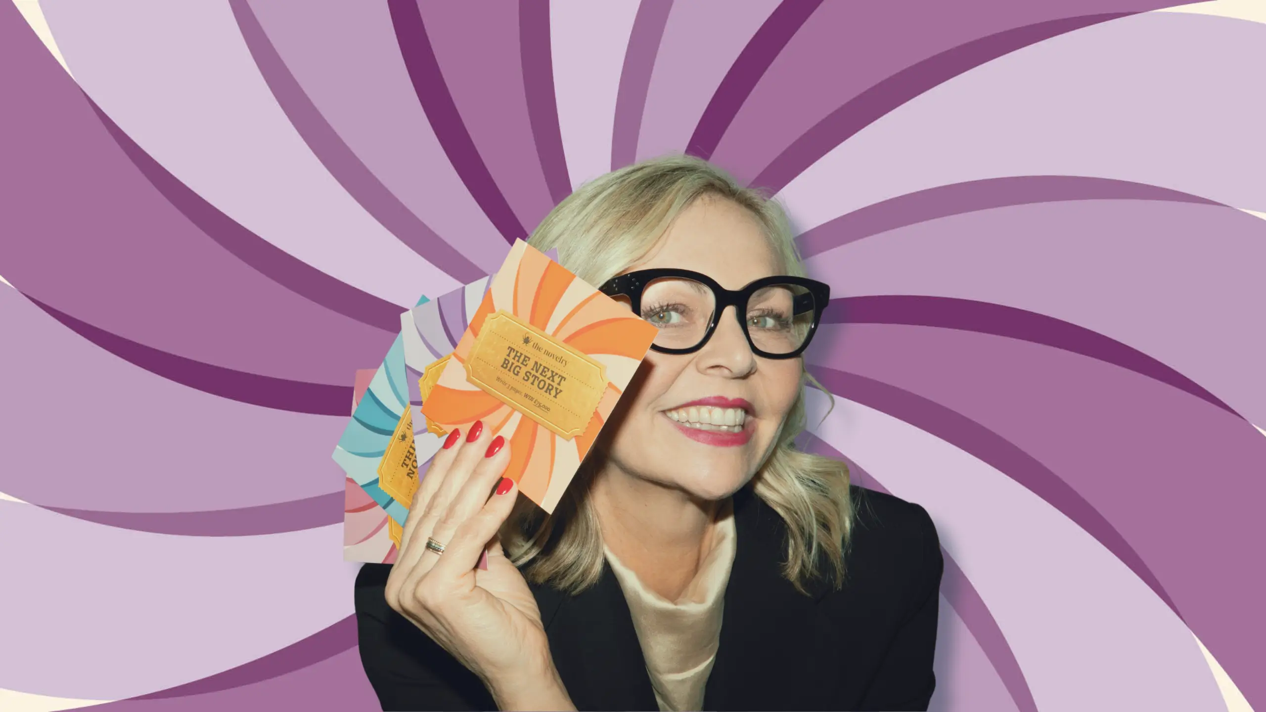 Founder of The Novelry, Louise Dean, holding cards to celebrate The Next Big Story writing competition.l