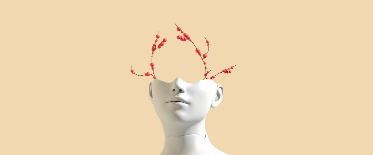 Half of a mannequin head is seen with red berries growing out of it.
