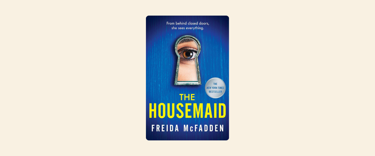 An image of a book cover with a woman's eye peeking through the keyhole. The book is The Housemaid by Freida McFadden.