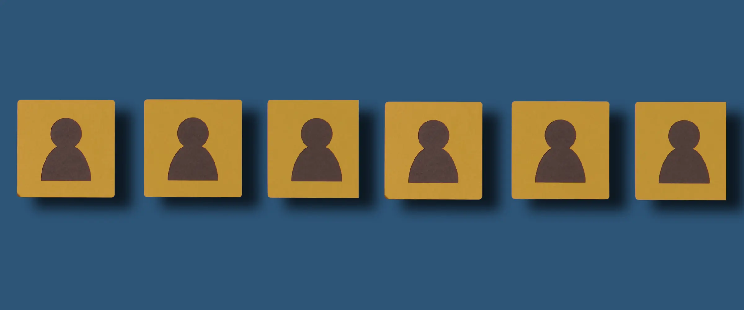 A row of blocks sits on a blue background. The blocks have the silhouettes of figures on them.