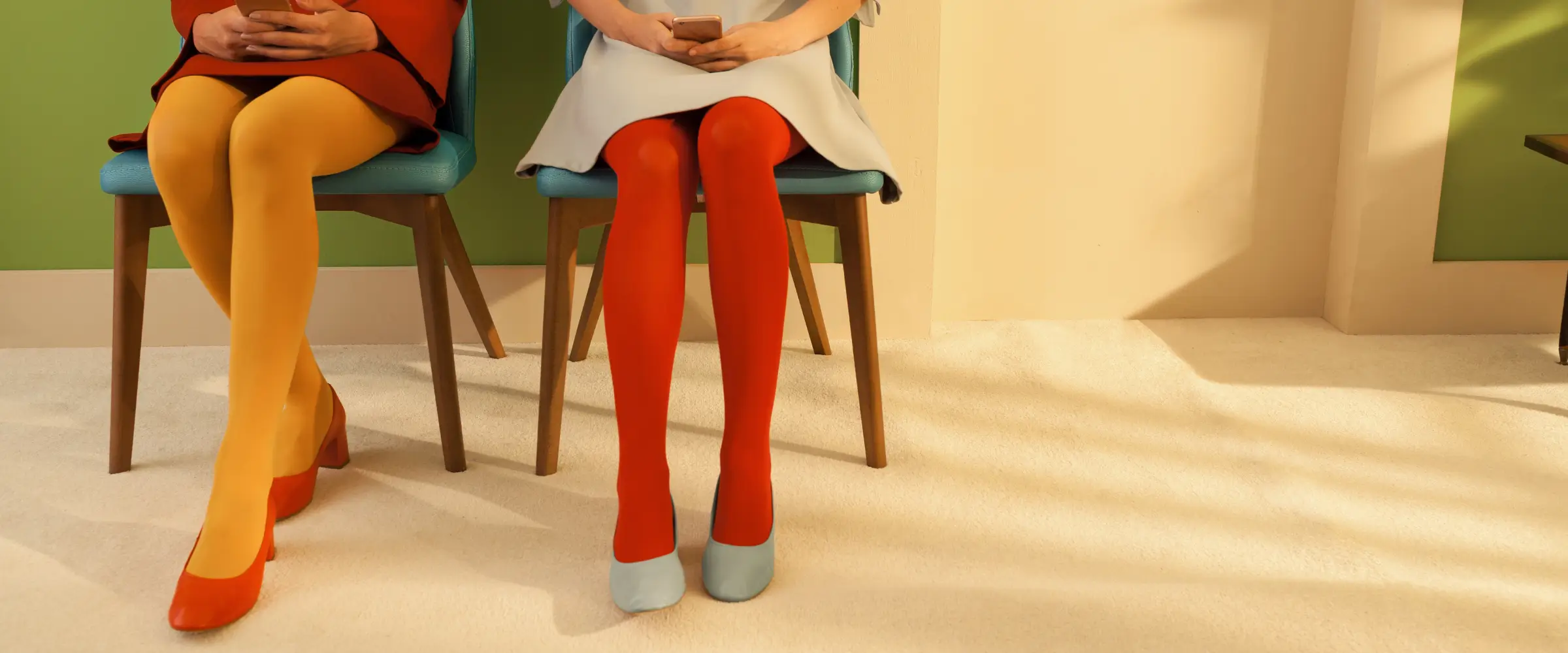 Two women sit on chairs waiting for something, in colorful outfits.