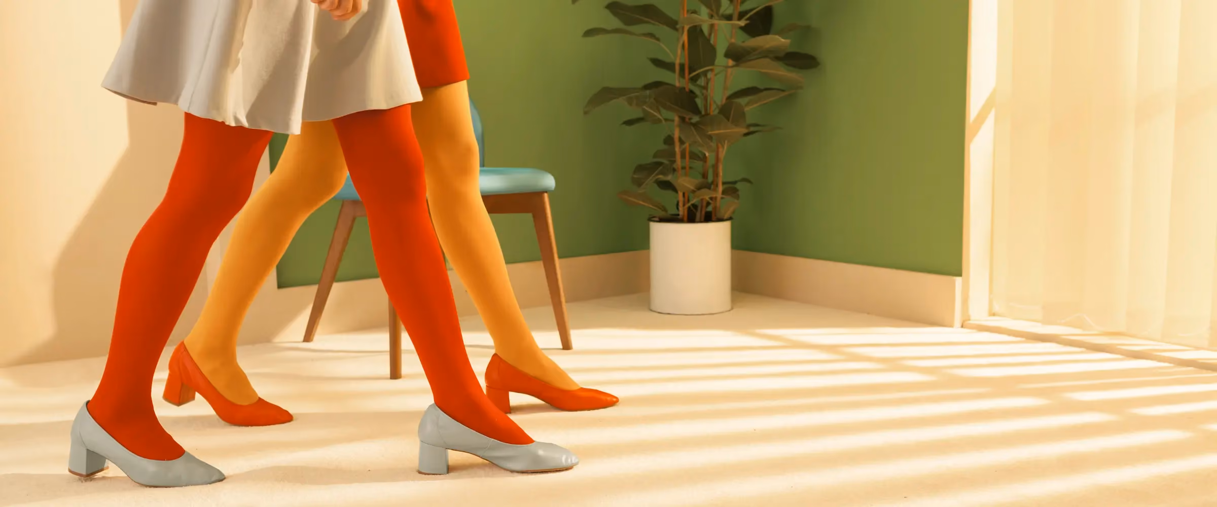 Two women in colorful outfits (shown as just skirts and legs) are walking through an office, with purpose.