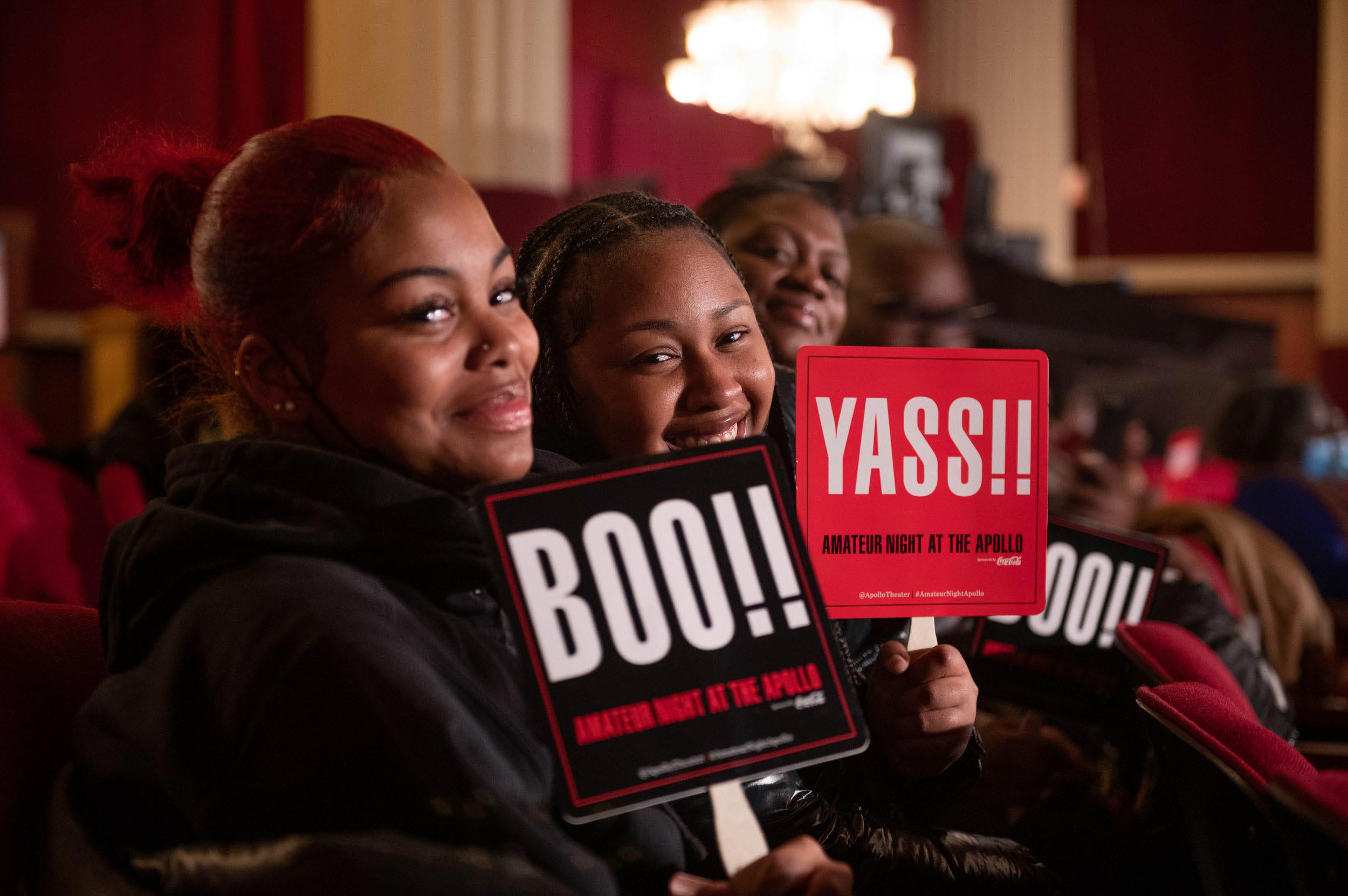 A group of people holding up signs that say "Yass!" and "Boo".