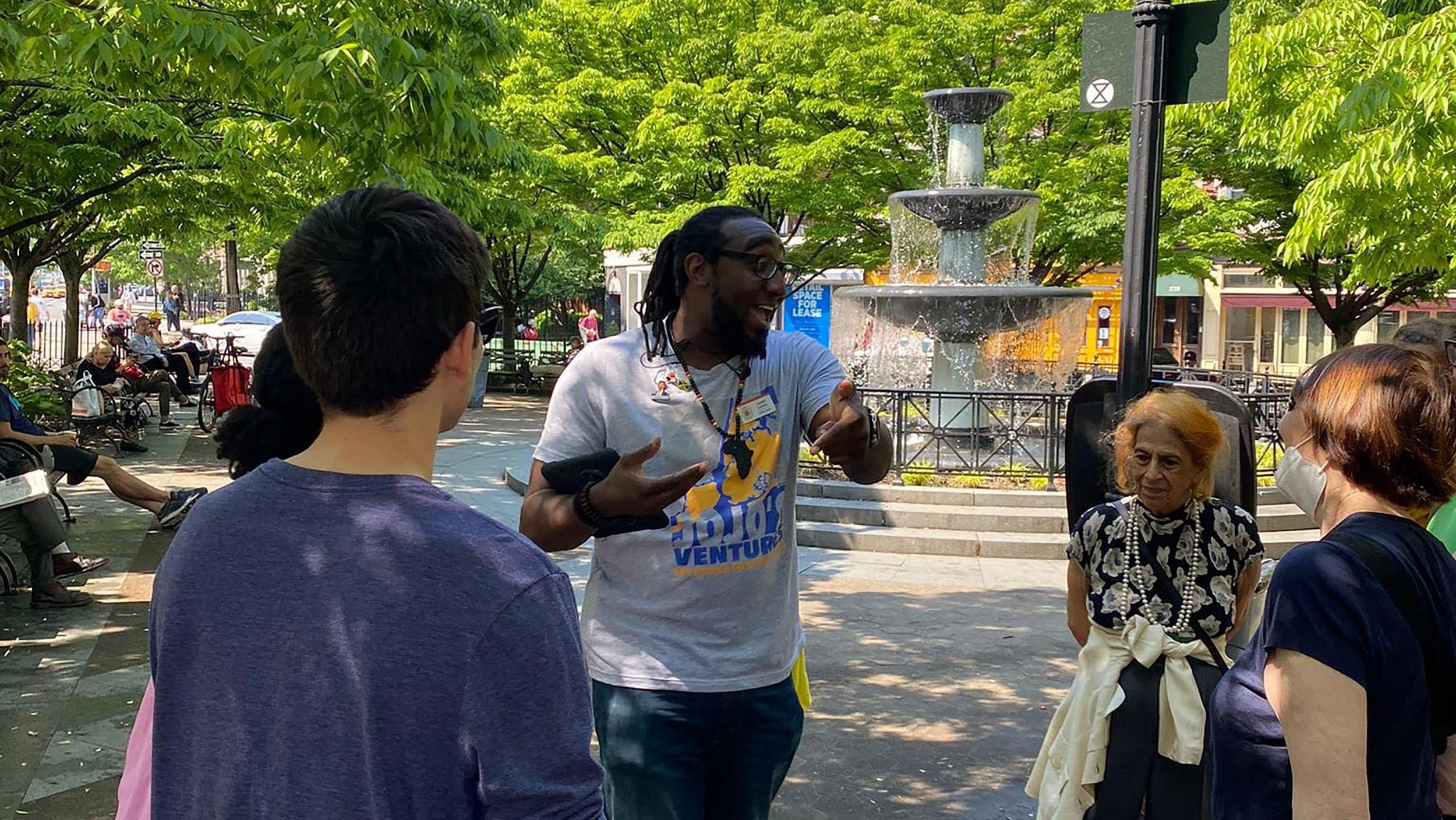 A Jojo's Adventures tourguide emphatically speaks to a group of onlookers.