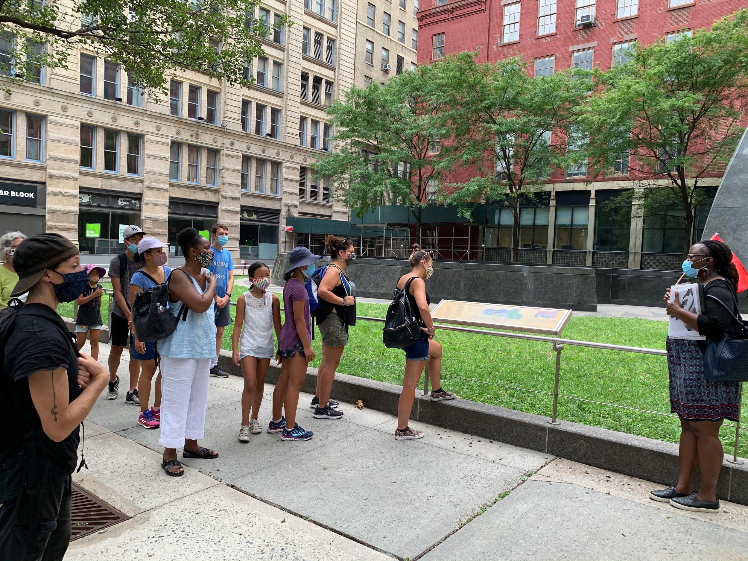 A group of people listen attentively to their tour guide.