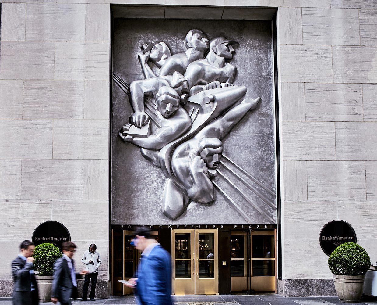 A huge art deco plaque depicting journalists at work looms over the entrance to 50 Rockefeller Plaza.
