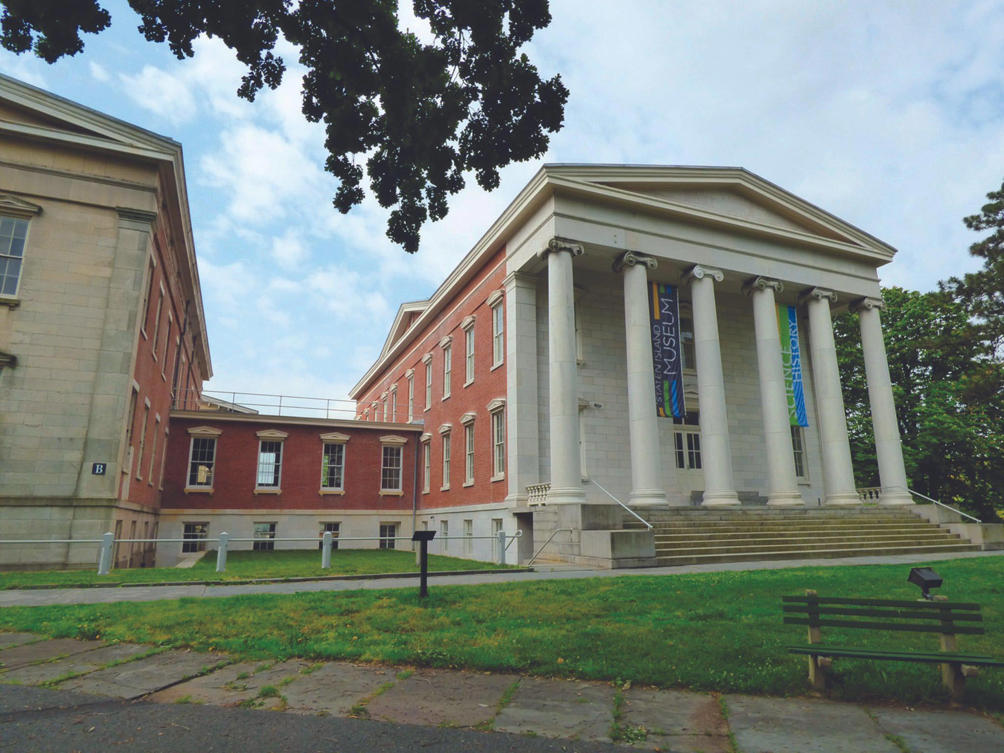 A large building with columns and a bench.