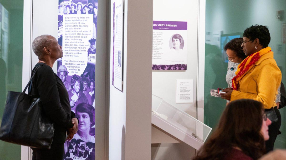 Museum visitors read through an exhibit about Mary Gray Brewer.