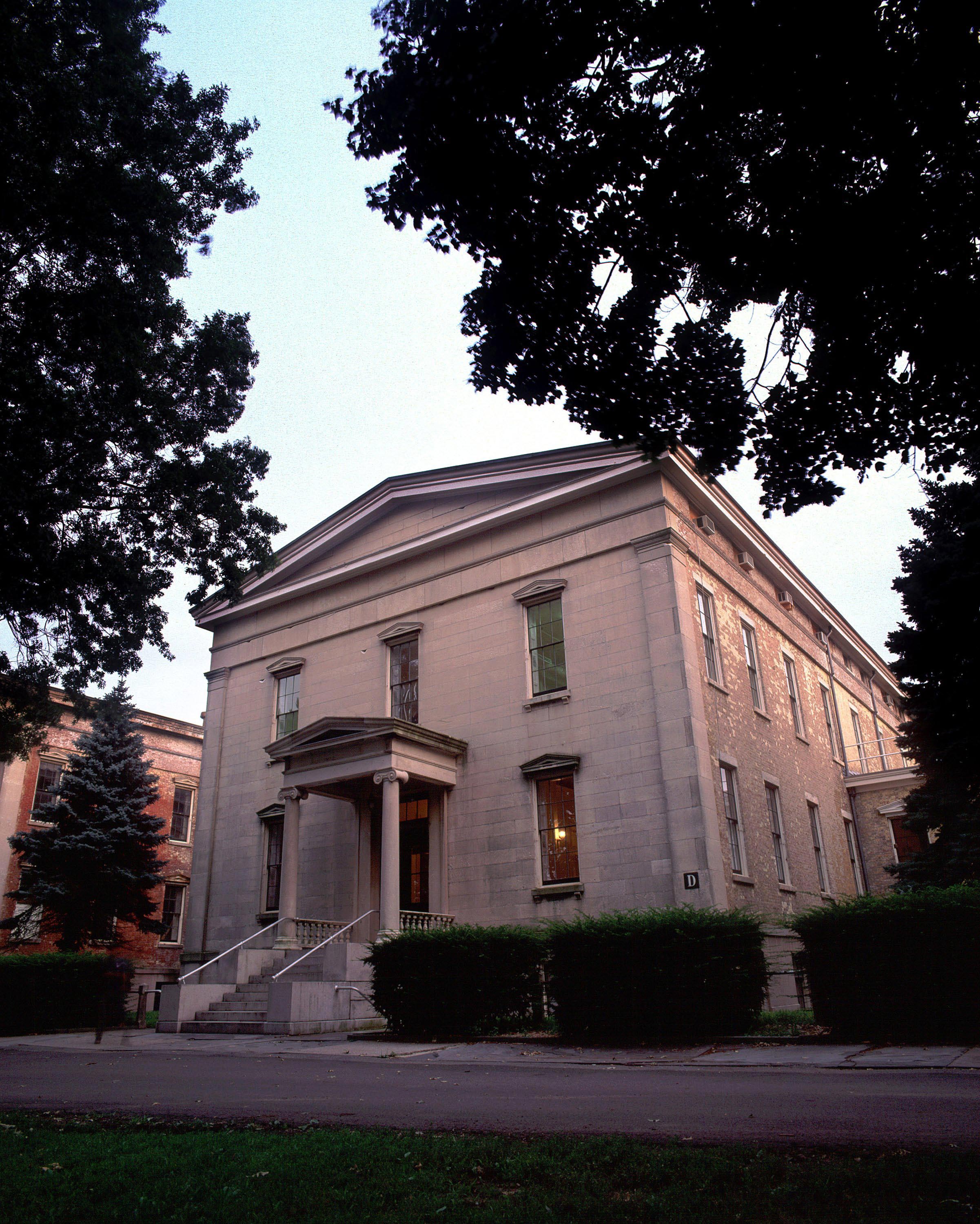 A large stone building with a tree in front of it