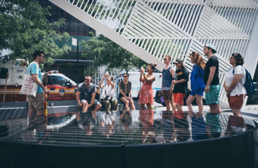 A group of people listen and take photos as a tour guide speaks.
