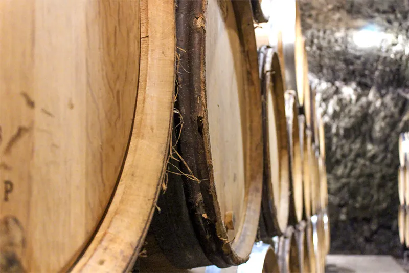 Fûts de chêne alignés dans la cave du Domaine Jean Monnier & Fils à Meursault pour l’élevage des vins de Bourgogne.