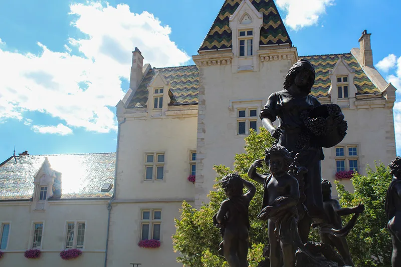 Mairie de Meursault avec son toit bourguignon typique et la statue des vendanges sur la place centrale.
