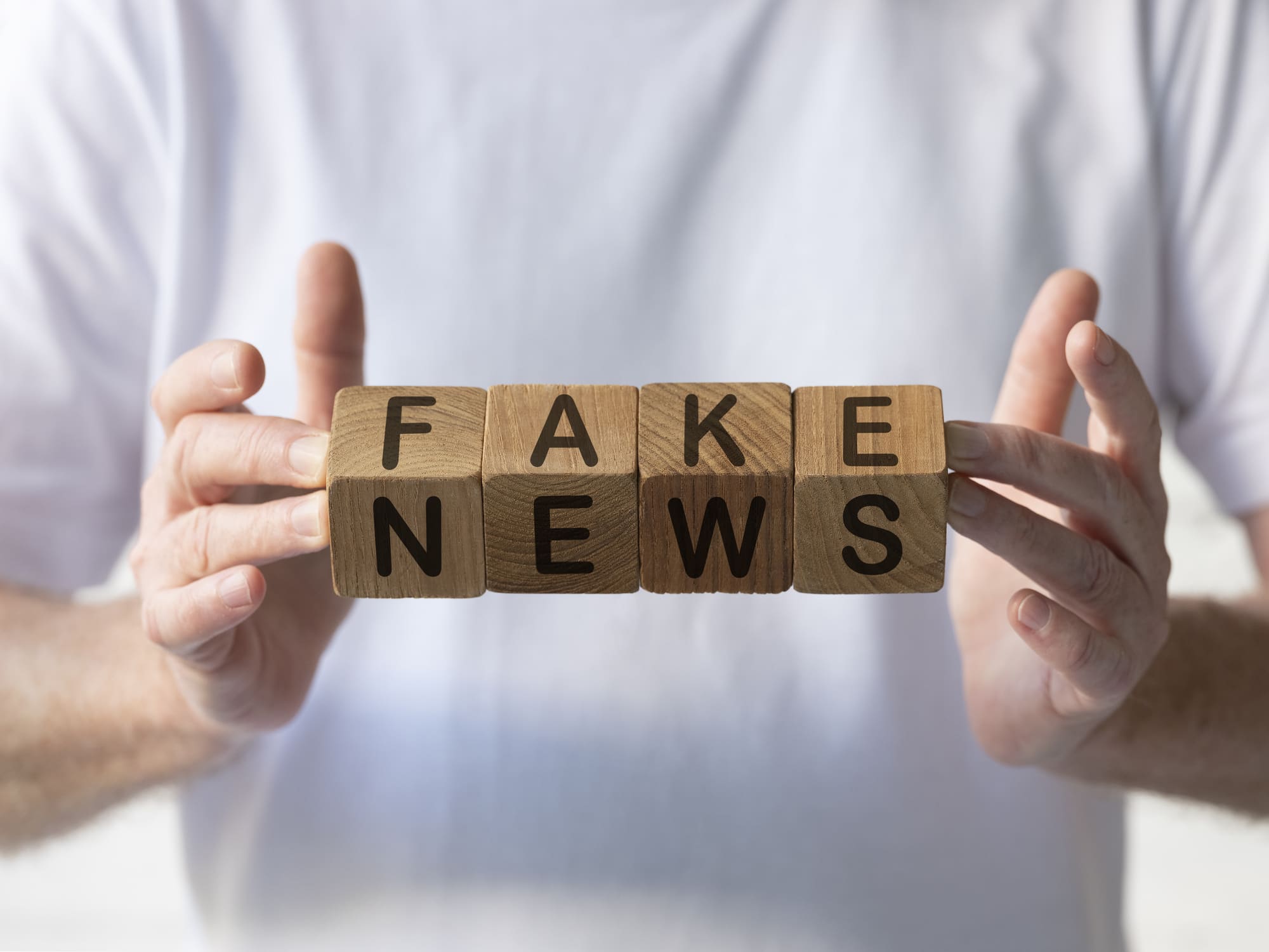 mains qui tiennent des lettres sur des cubes en bois