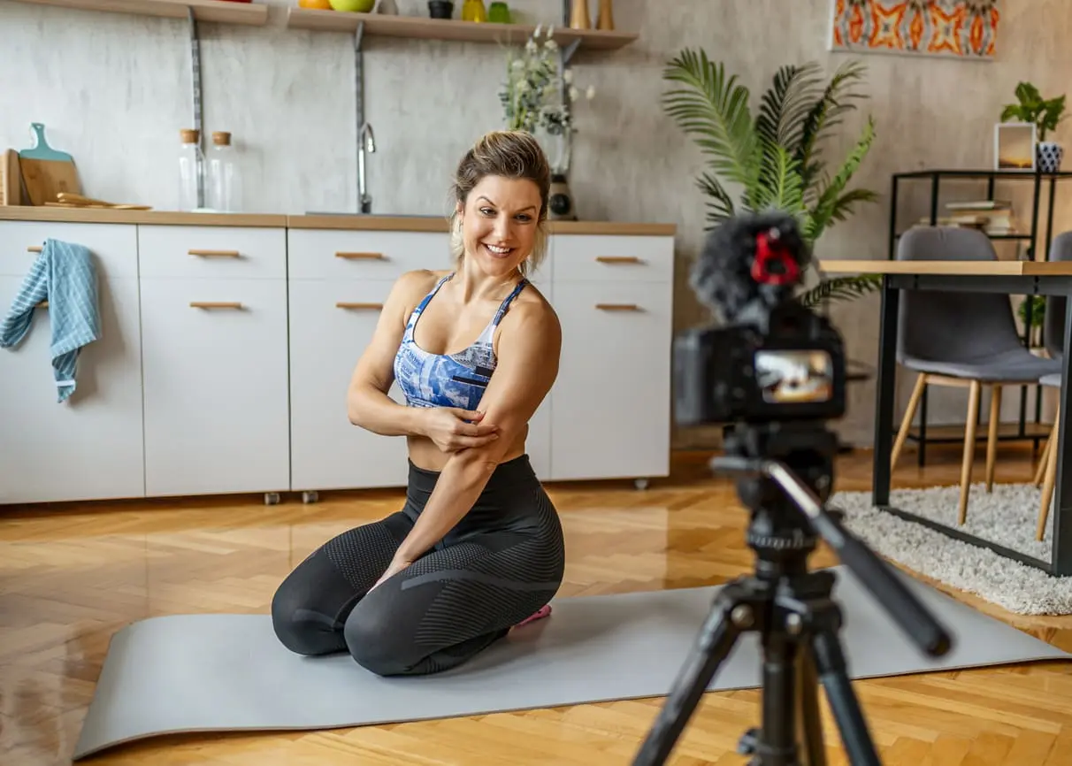 Fitness influencer recording workout video at home