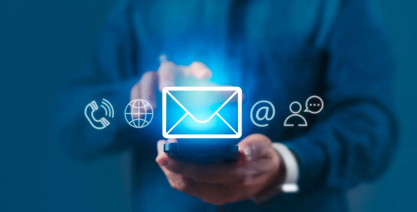 Un hombre sostiene un teléfono celular con un icono de comunicación en la pantalla