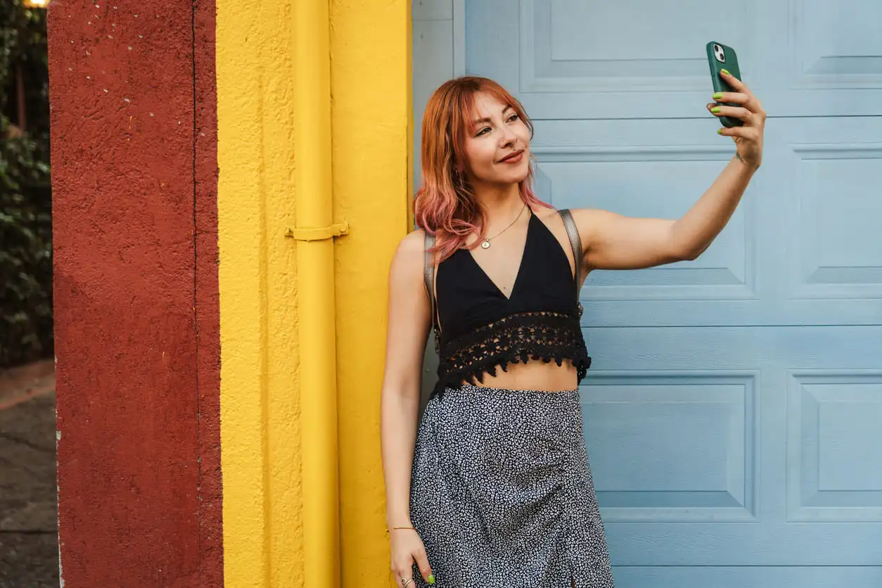 Mujer joven tomándose un selfie en la calle colorida de Oaxaca