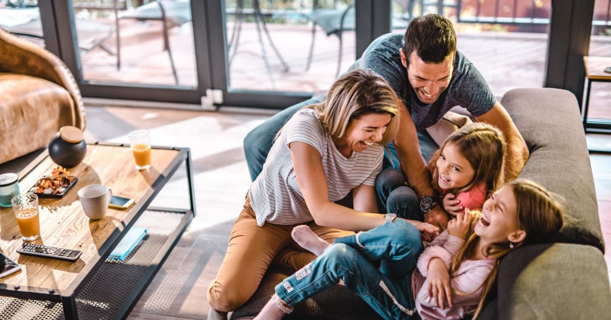 familia feliz jugando en un sofá
