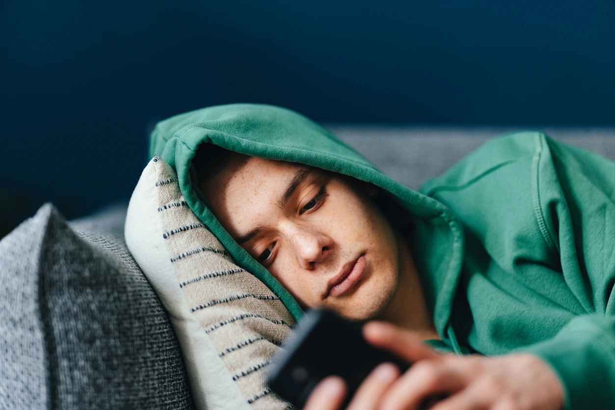 homme sur son téléphone allongé