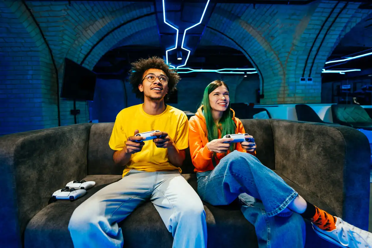 Grupo multiétnico de jóvenes amigos jugando videojuegos en casa