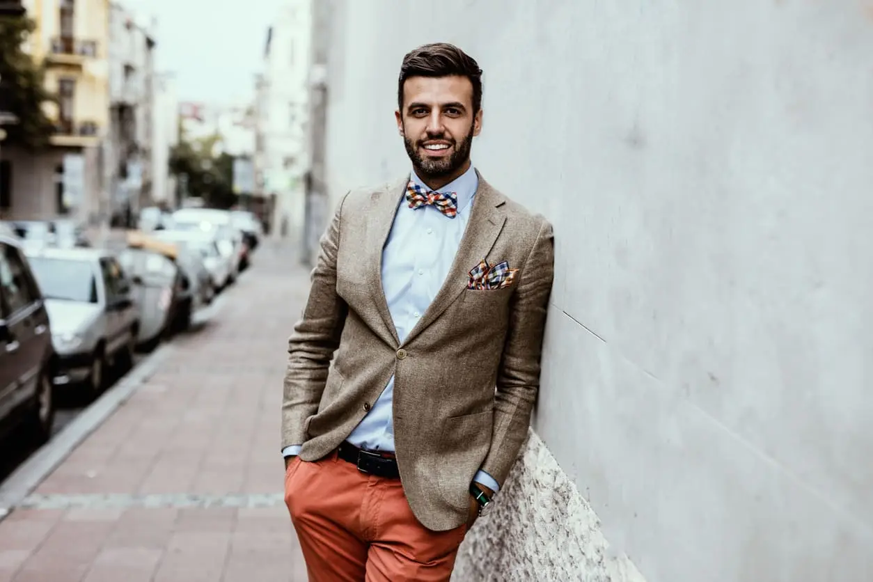 Portrait de blogueur mode beau jeune s’est penché sur le mur.