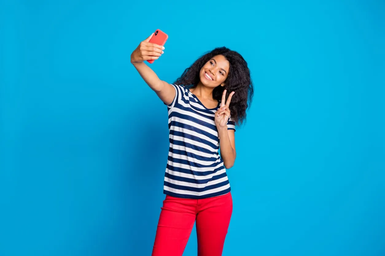 femme métisse tenant son téléphone sur fond bleu