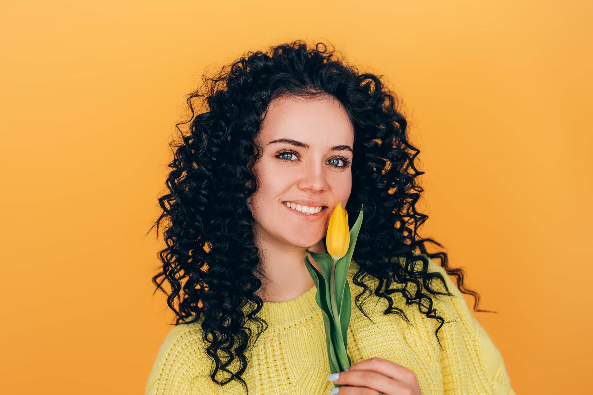 Jeune belle fille retenant le bouquet des tulipes