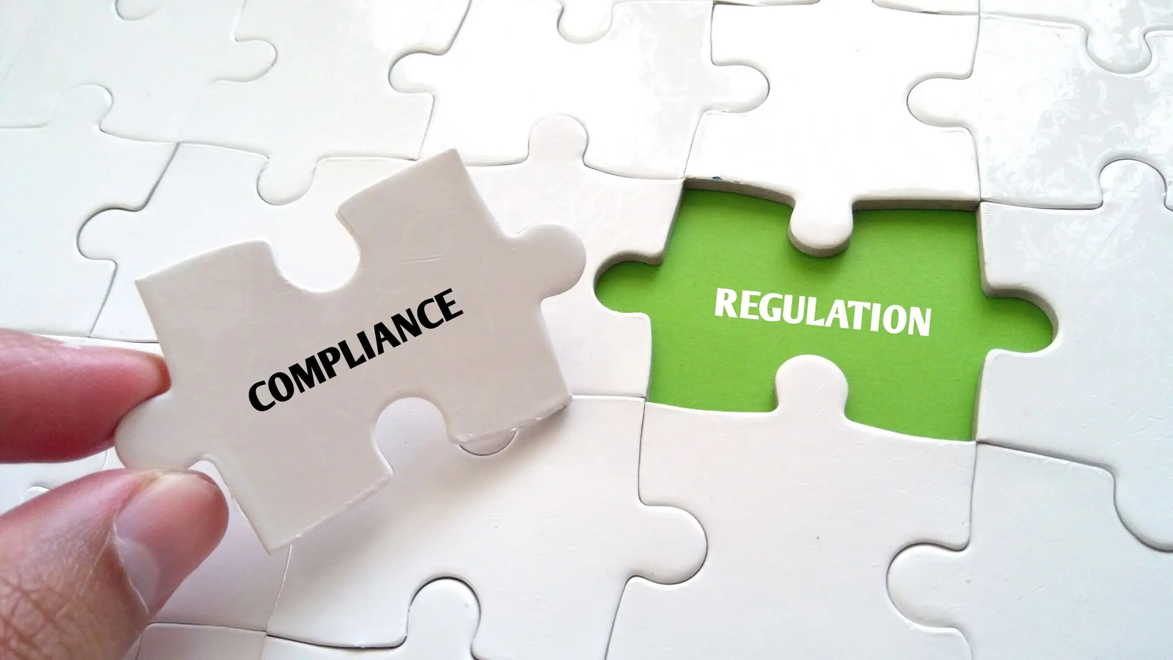 Main et puzzle manquant avec COMPLIANCE REGULATION WORD